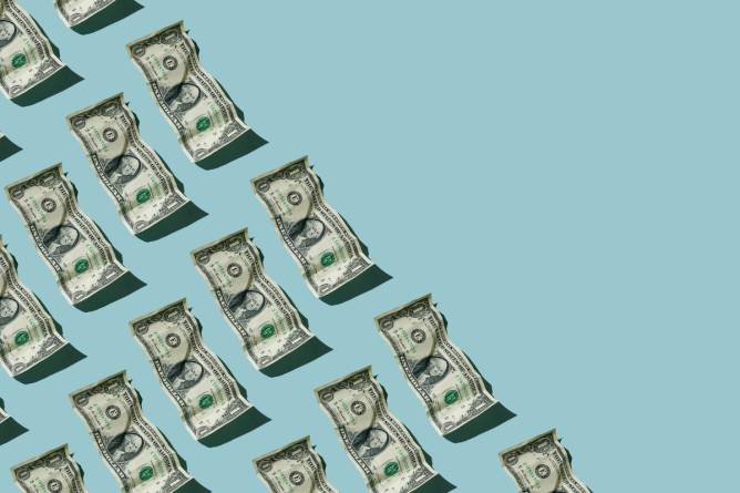 crumpled dollar bills on a light blue background