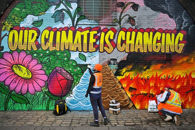 Artists paint a mural ahead of the COP26 summit in Glasgow 
