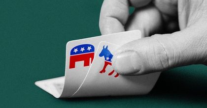 Closeup of a hand lifting up two poker cards displaying the Republican and Democrat animal mascots of elephant and donkey
