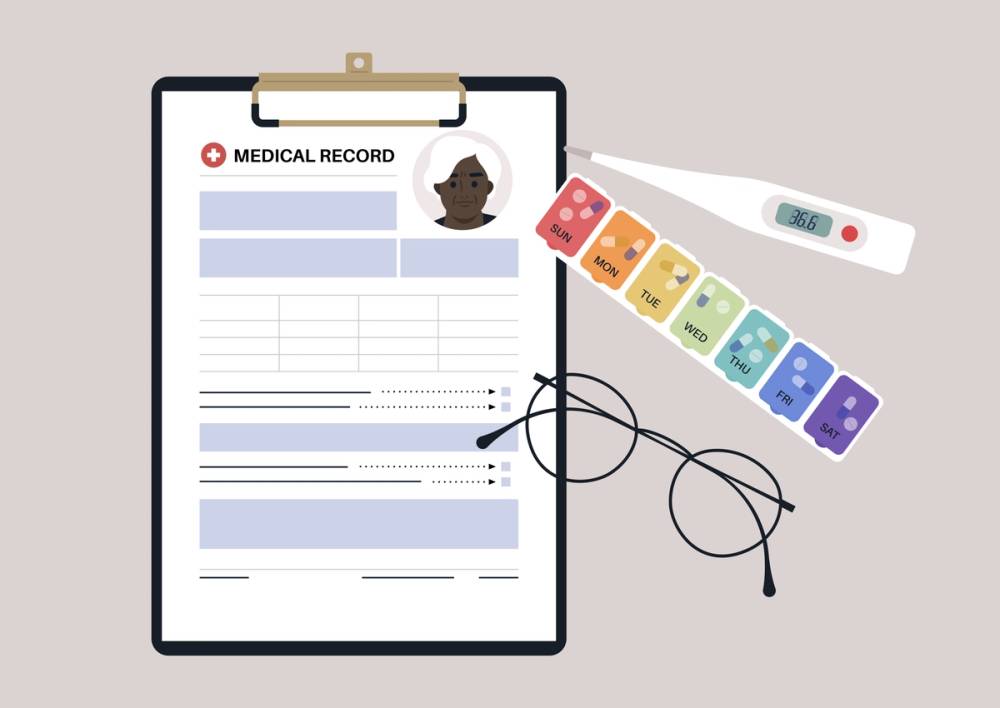 A set of senior patient's medical chart clipped to a clipboard, pill box, glass frames, and plastic thermometer