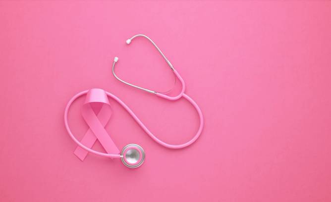 Pink breast cancer ribbon and a stethoscope on a pink background
