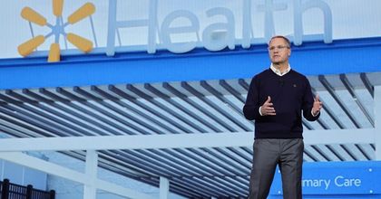 Doug McMillon, CEO of Walmart, speaking during a keynote address in front of a Walmart Health.