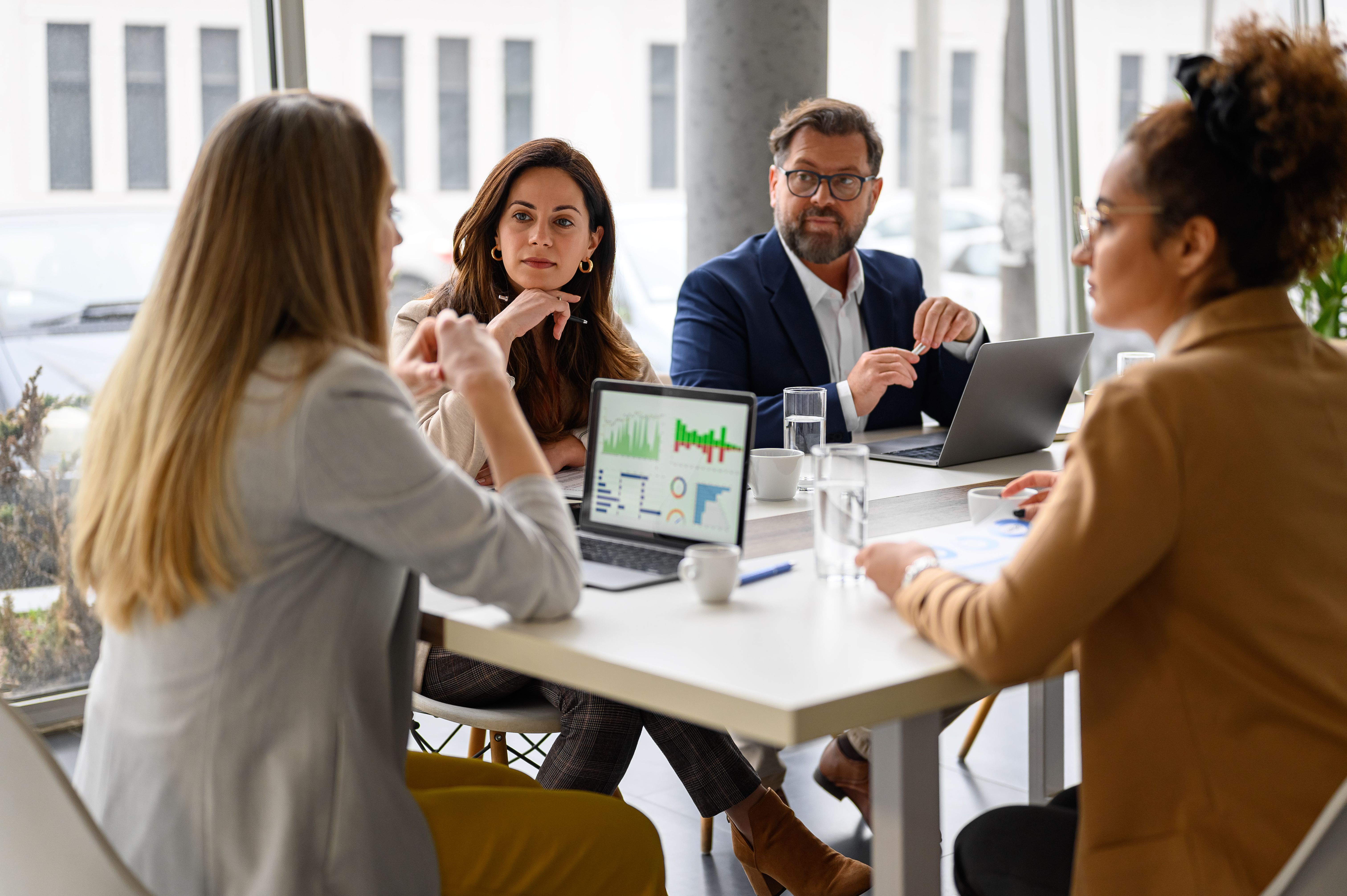 A team of colleagues in a conference room discussing strategy.