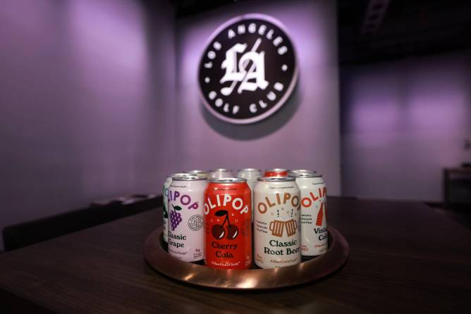 Cans of Olipop in front of Los Angeles Golf Club logo