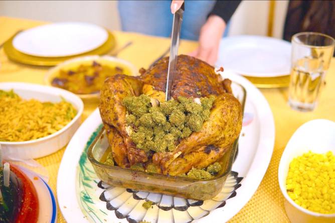 Someone is carving a turkey on a typical Thanksgiving table, except rather than stuffing, it's stuffed with cannabis. 