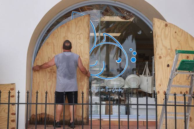 People in Florida covering windows with plywood in advance of Hurricane Helene