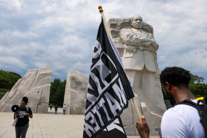 A Black person holds a Black Lives Matter flag during a 2021 Juneteenth observance.