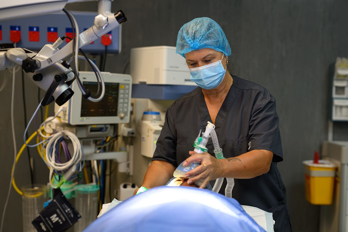 Anesthesiologist holds breathing device over patient