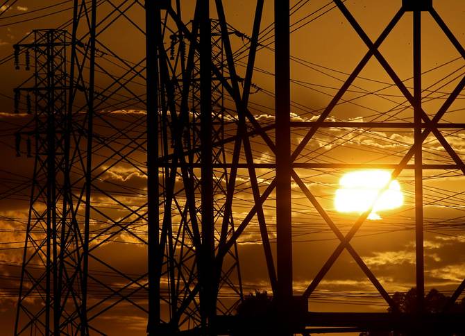 The sun sets behind power lines on a warm afternoon in Long Beach, where temperatures reached into the low 80s on Tuesday, Aug. 16, 2022