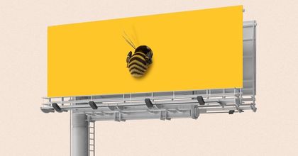 A giant bumblebee sitting on an all yellow billboard