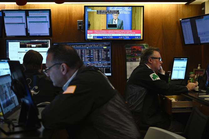Traders at their stations with Jerome Powell in the background
