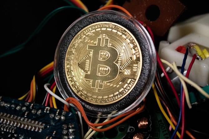 Image of a physical bitcoin sitting on a bunch of wires