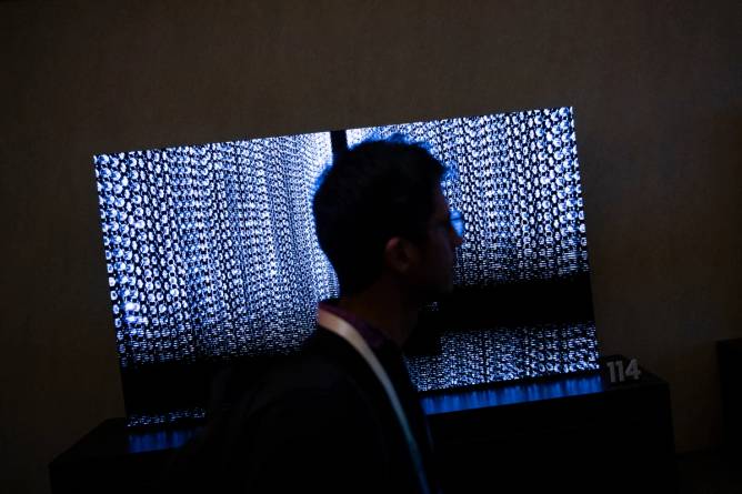 A person walks past TV screens at the Samsung First Look preview at the Caesars Palace resort a pre-show for this weeks Consumer Electronics Show January 7, 2024, in Las Vegas, Nevada.