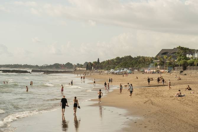 Tourists enjoy the popular surf beach at Batu Bolong on December 8, 2022 in Canggu, Bali, Indonesia.