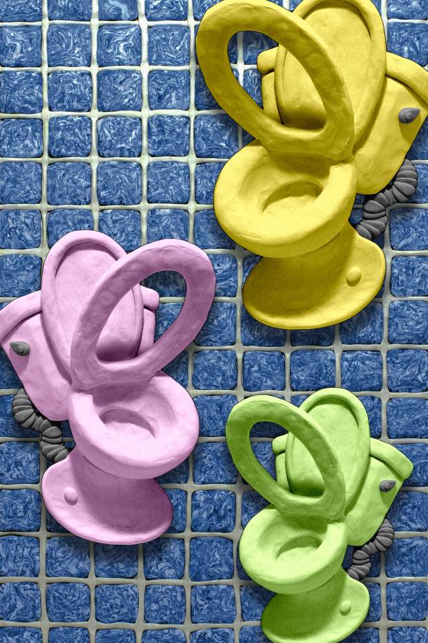Colorful clay sculptures of Toilets against a background otile and grout