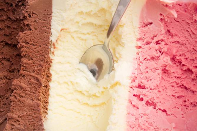 An ice cream container with three flavors: chocolate, vanilla, and strawberry. 