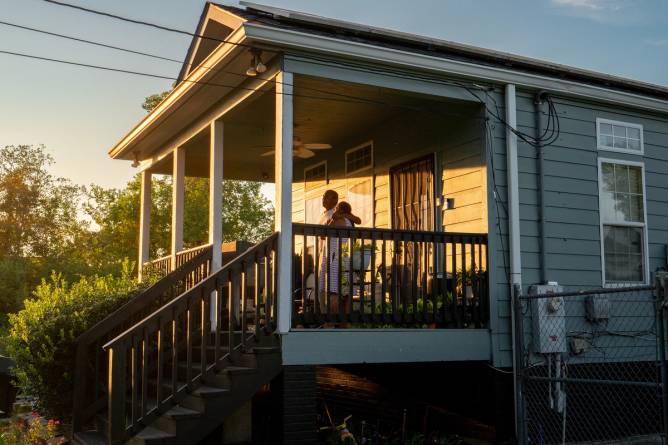 a couple stand on a porch in New Orleans