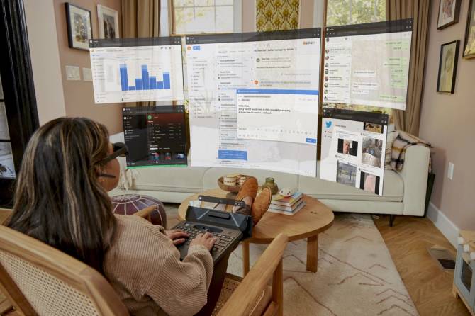 Image of a woman working at a Sightful mixed reality laptop.