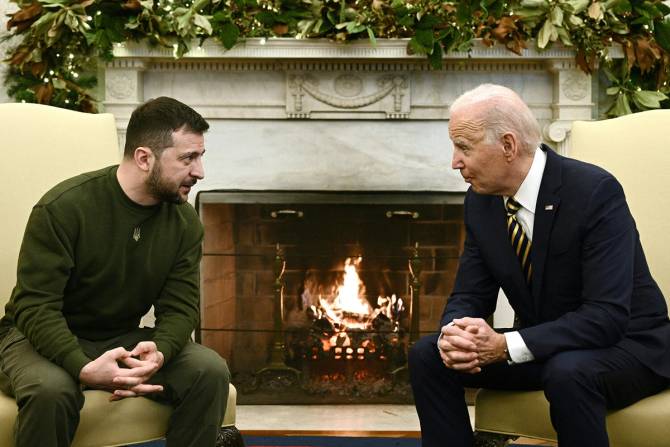 Zelensky and Biden talking next to a fireplace at the White House