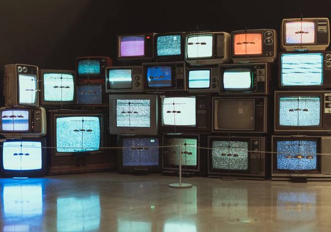 Old television sets stacked on top of each other displaying static