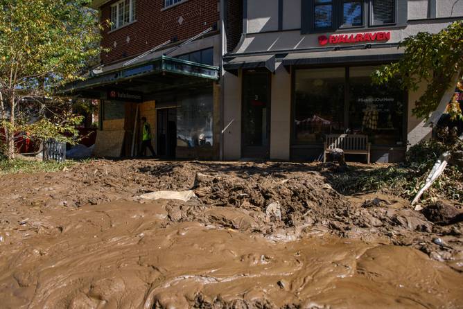 Stores int he Biltmore Village are seen with a sea of mud in front of them in Asheville, NC on October 8, 2024