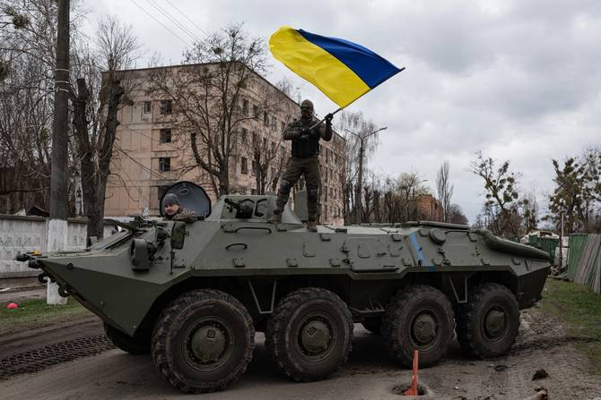 Ukrainian holding a flag on top of a tank