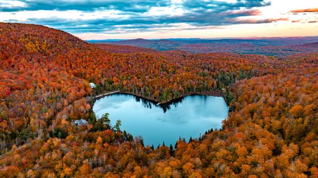 In this aerial image, Baker Lake is surrounded by Fall colors on October 8, 2022 near East Bolton, Quebec, Canada.