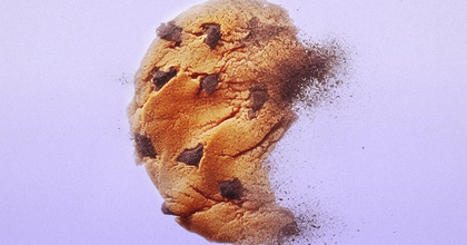 A chocolate chip cookie disappearing in to thin air on a light purple backdrop