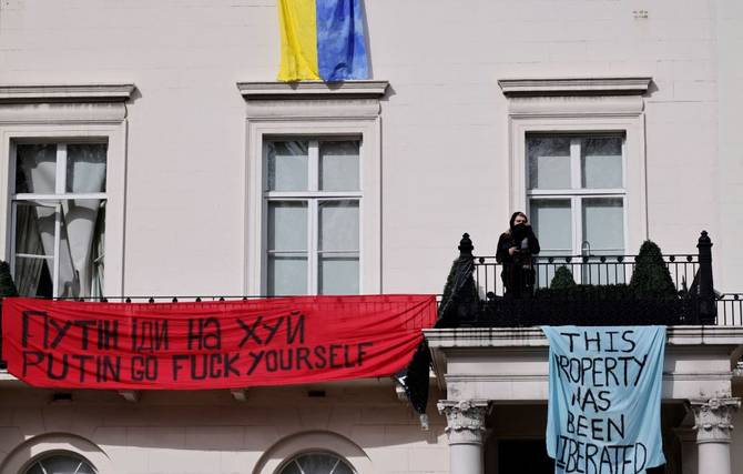 Protestors on the facade of a mansion supposedly belonging to a Russian oligarch
