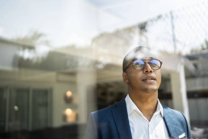 A man staring out of an office window.