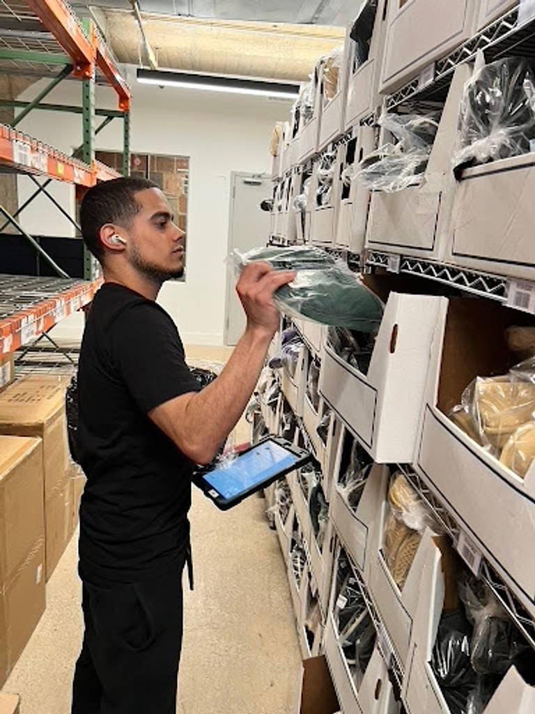Jonathan Acevedo removes slippers from a warehouse shelf. 