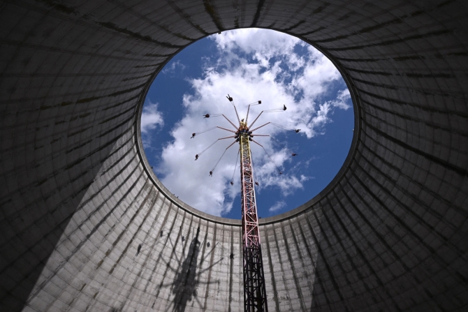 People ride a swing in a nuclear power plant cooling tower