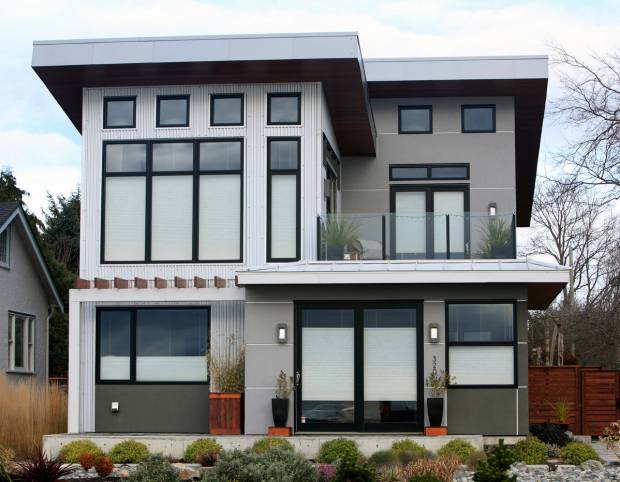 Modern residential high two story home. Exterior has Metal Cladding,wood,large stone or concrete blocks.
