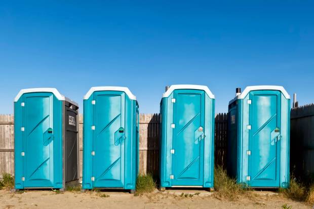 Four portable toilets at a beach
