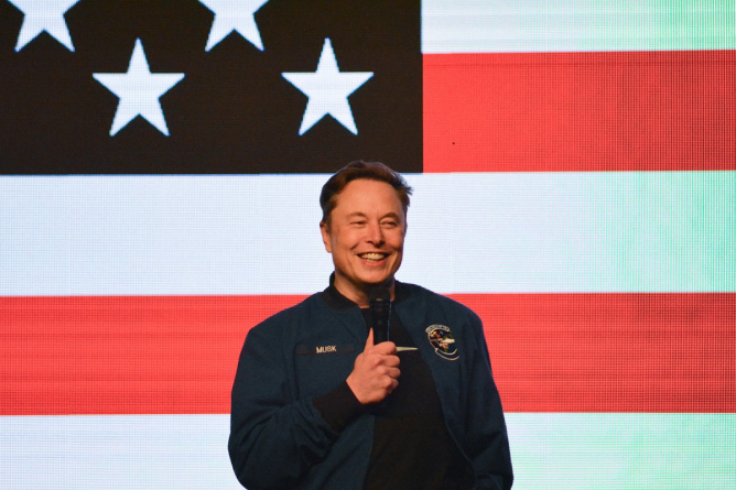 Elon Musk speaks during a town hall meeting in Wisconsin in front of an American flag