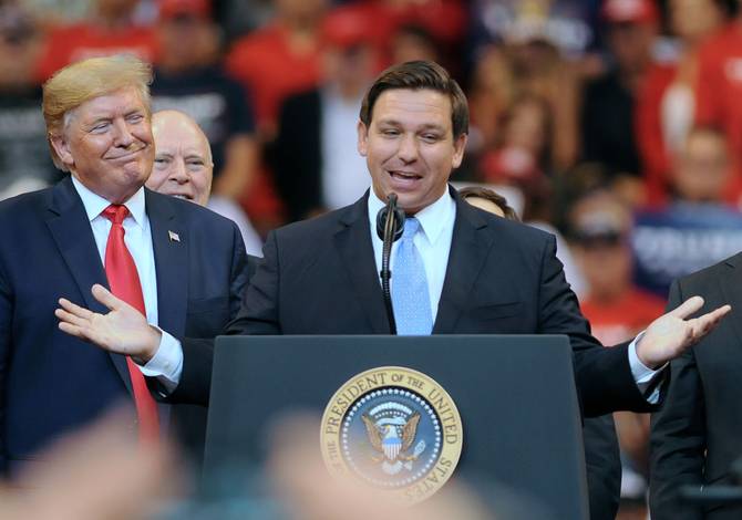 U.S. President Donald Trump looks on as Florida Governor Ron DeSantis speaks during the Florida Homecoming rally at the BB&T Center