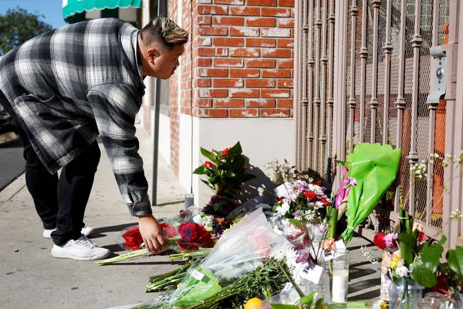 A person places flowers at a makeshift memorial outside the scene of a deadly mass shooting in Monterey Park, California