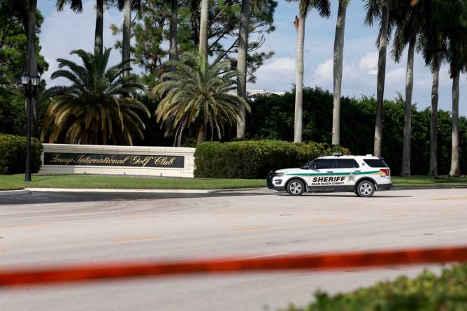 the entrance of Trump International Golf Course with a sheriff's SUV parked nearby