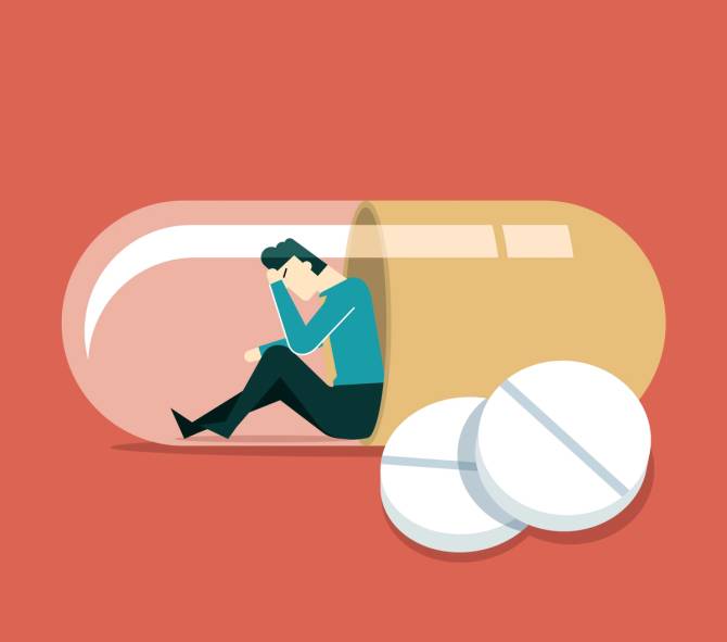 A graphic of a man looking forlorn inside a pill