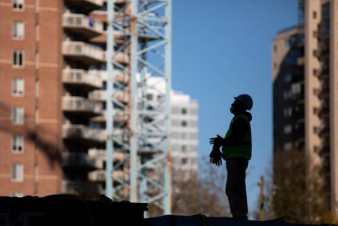 Construction worker looking up at building