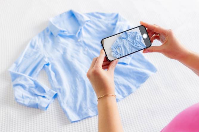 Woman taking photo of her used clothes in order to sell them online.