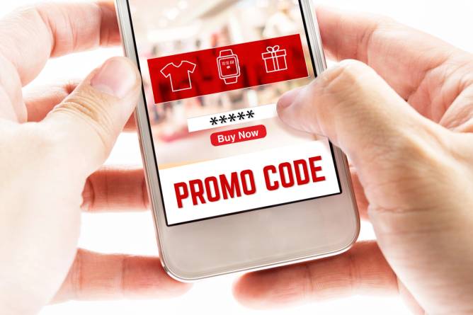 Close-up of two hands holding mobile phone with promo code.