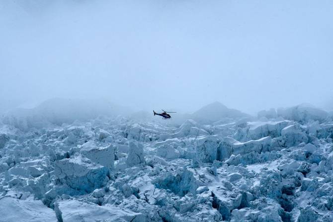 A helicopter flies over Khumbu glacier in the Mount Everest region