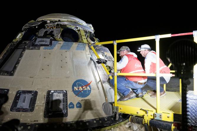 Boeing and NASA teams work around NASA's Boeing Crew Flight Test Starliner spacecraft after it landed uncrewed at White Sands Space Harbor