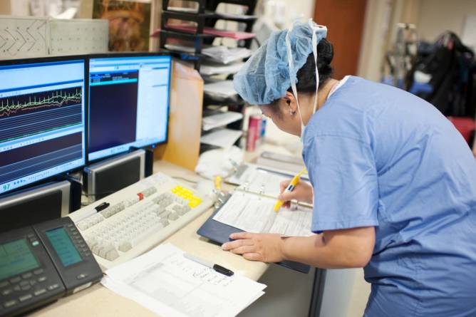 Nurse prepares surgical paperwork