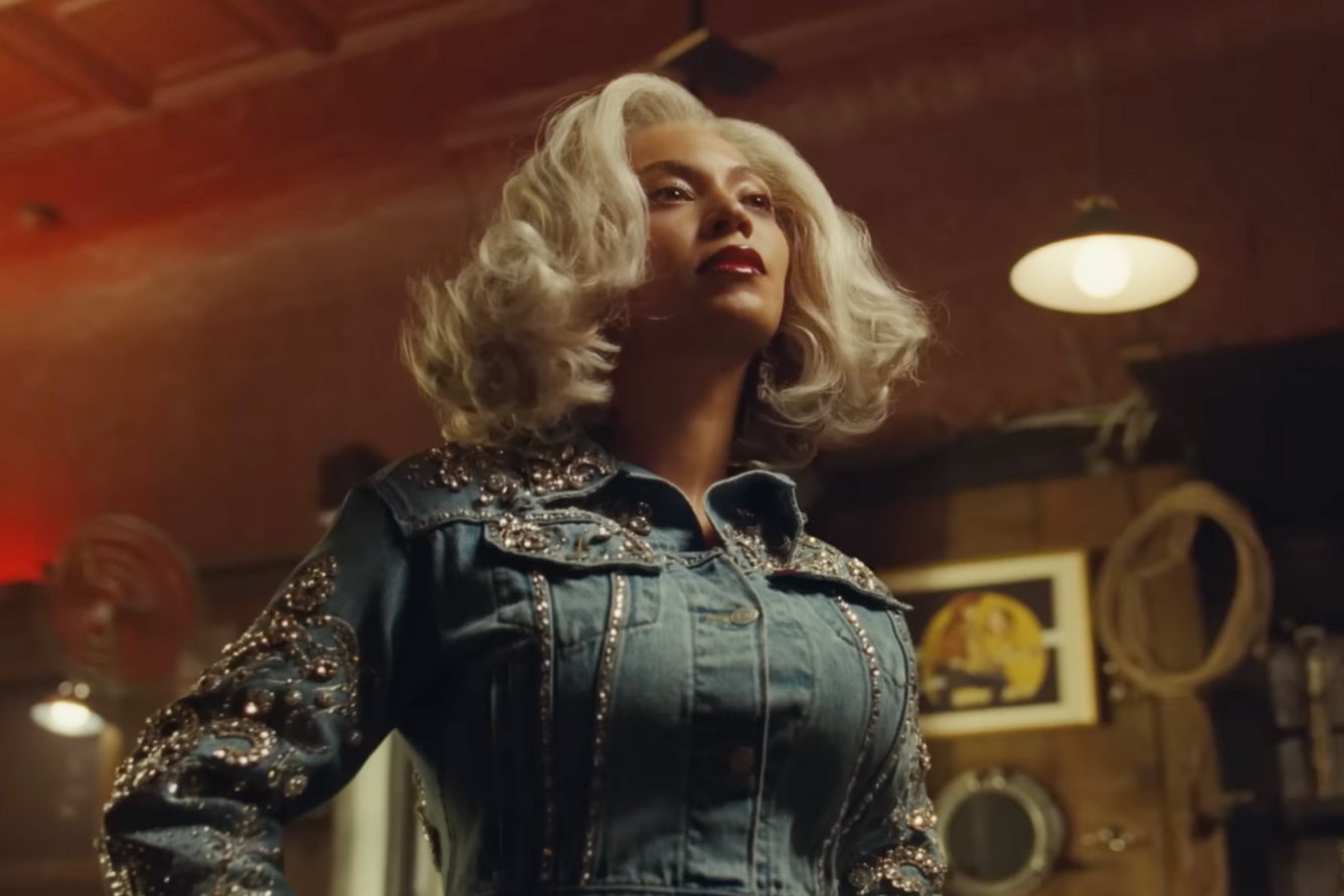 Beyonce wears a rhinestoned denim outfit with her hands on her hips in an ad for Levi's called "Pool Hall"