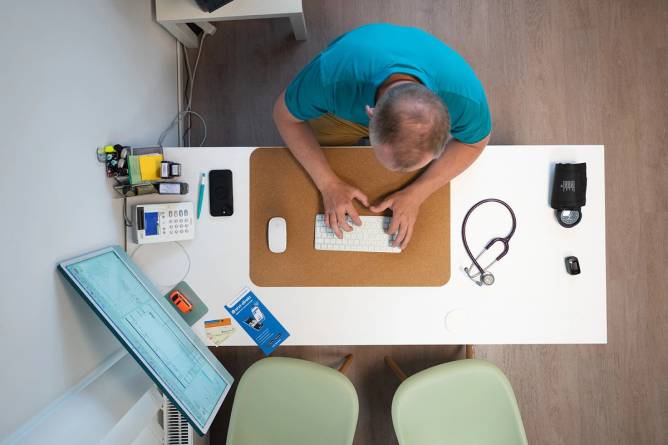 Doctor sitting at a desk with a computer