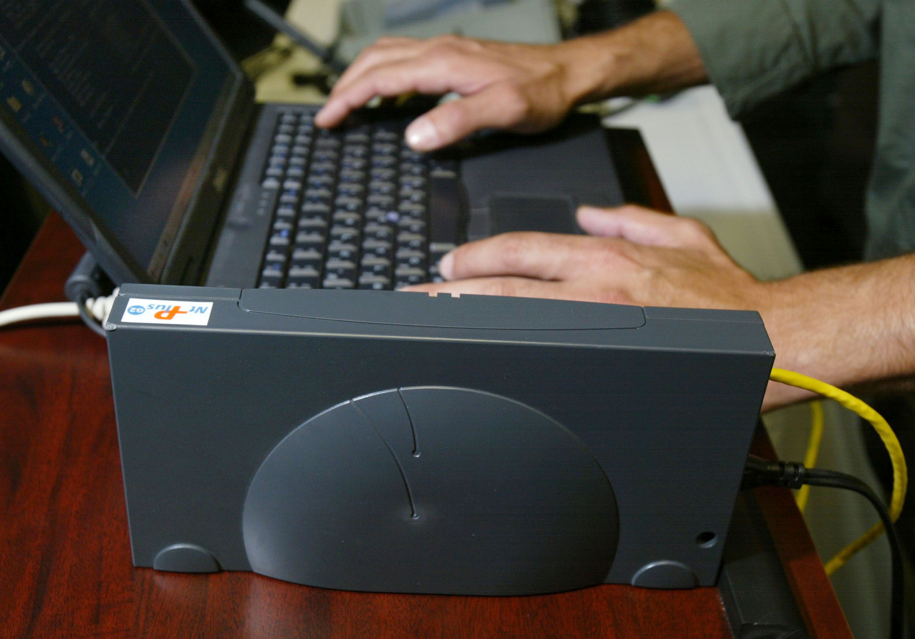 A Broadband Over Power Line modem is sits next to a laptop