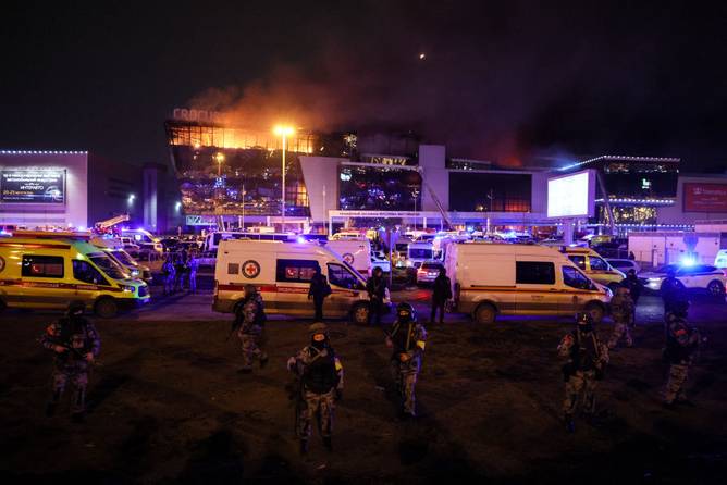 Law enforcement officers are seen deployed outside the burning Crocus City Hall concert hall following an ISIS attack