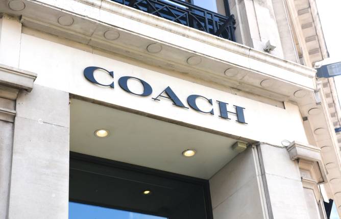 Coach store sign on building exterior.